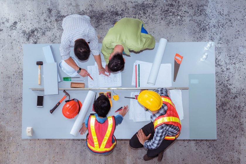 overhead view of construction workers planning at a table