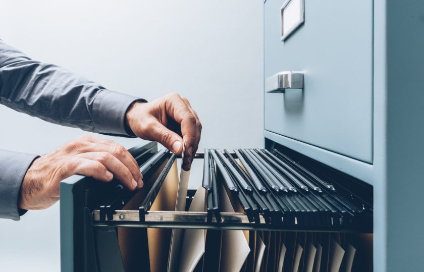 Hand pulling files from filing cabinet drawer