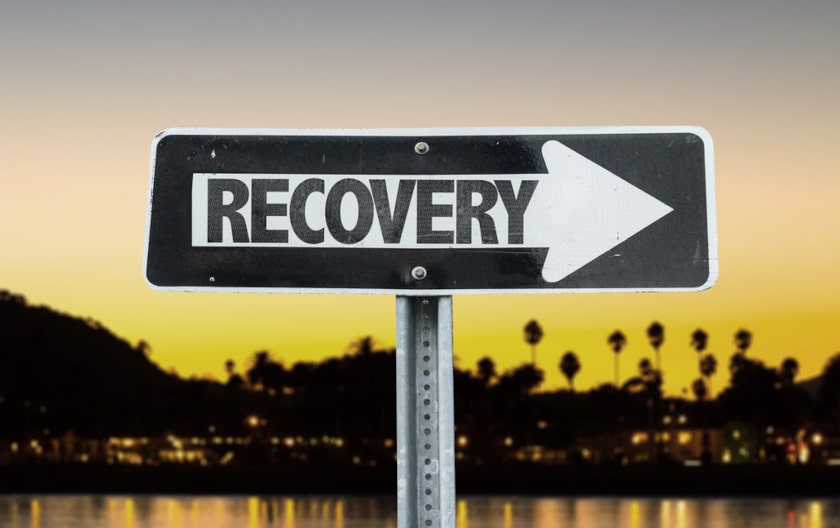Recovery direction sign with sunset background