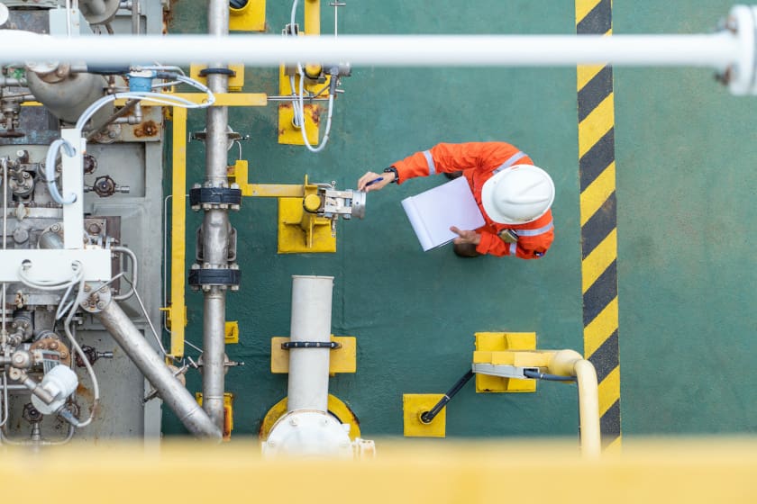 man in hard hat doing scheduled preventive maintenance work on machinery