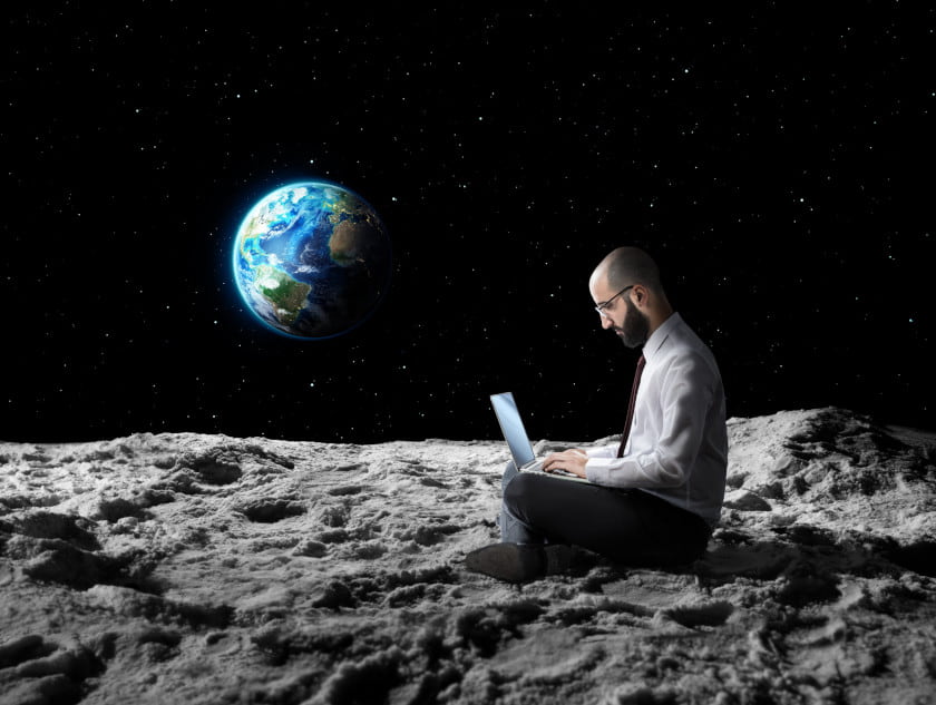 man working on laptop remotely from the moon